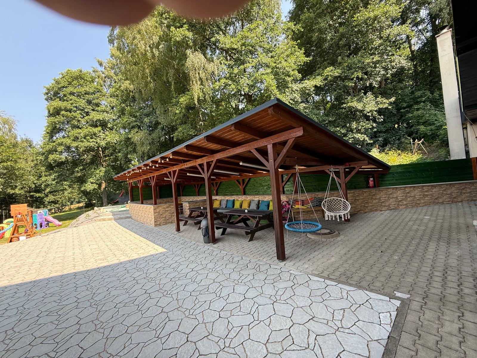 Venkovní krytá pergola pro 40 osob s posezením a houpačkami
